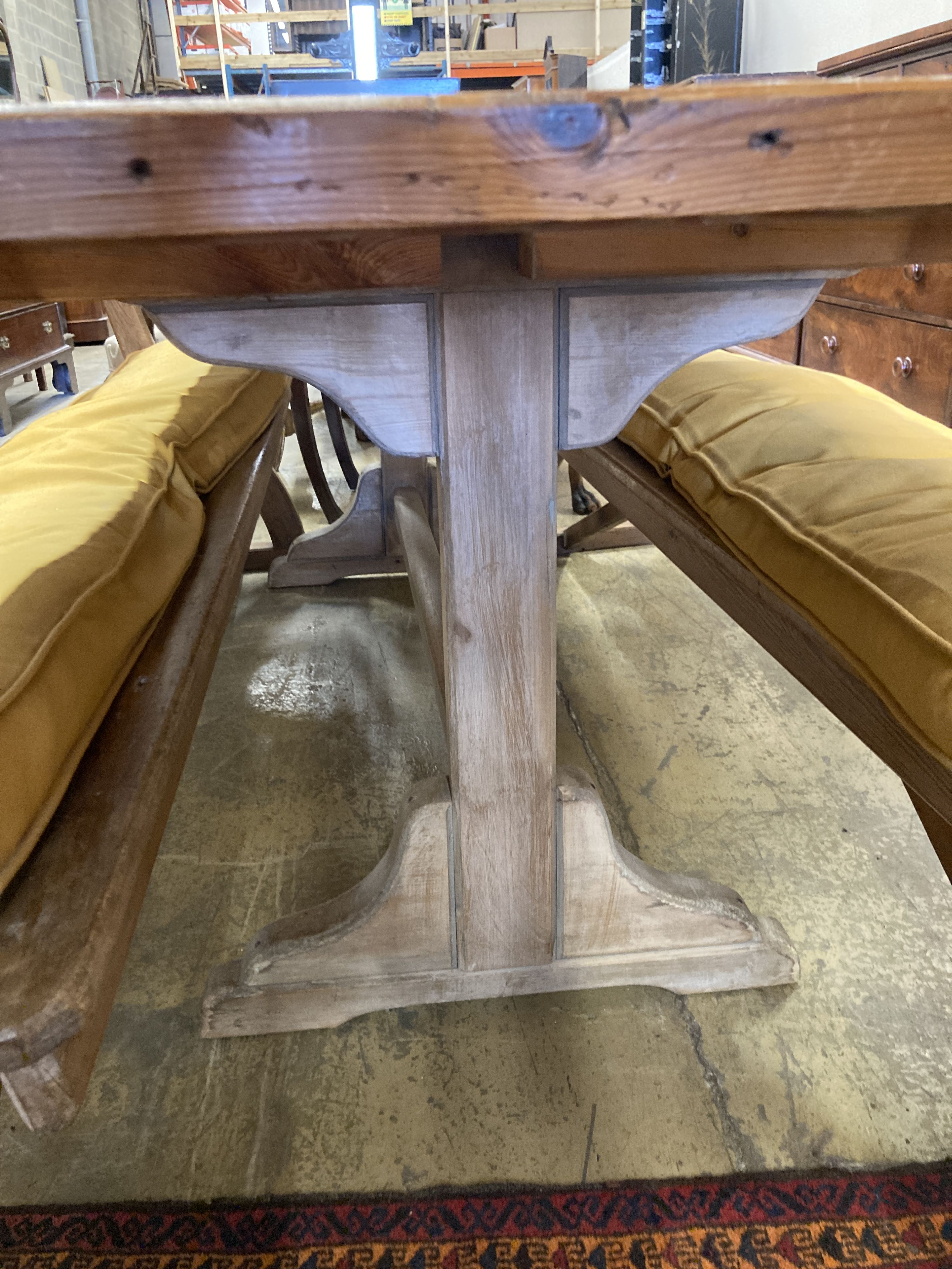A rectangular pine kitchen table, width 218cm, depth 77cm, height 77cm together with a pair of Victorian pitch pine bench seats